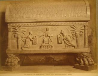 Footed casket, two figures bring offerings to central seated figure; curved top is patterned with overlapping leaves.