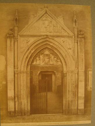 Gothic arched, iron gated entry, surmounted by a pediment.