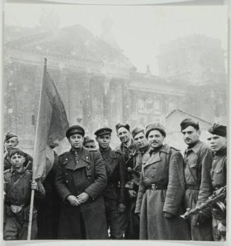 On the Road to Berlin (Shagin (under the flag) with members of Captain Neustrelvas battalion in front on the newly captured Reichstag, May 1, 1945)